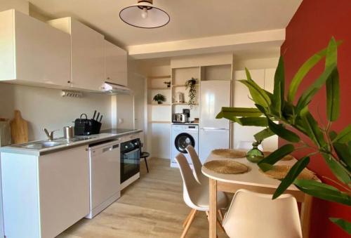 une cuisine avec une table et une salle à manger dans l'établissement T3 de charme climatisé - Piscine - Plage à 5 min, à Gruissan