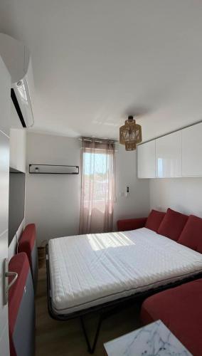 - une chambre avec un lit et un canapé rouge dans l'établissement T3 de charme climatisé - Piscine - Plage à 5 min, à Gruissan