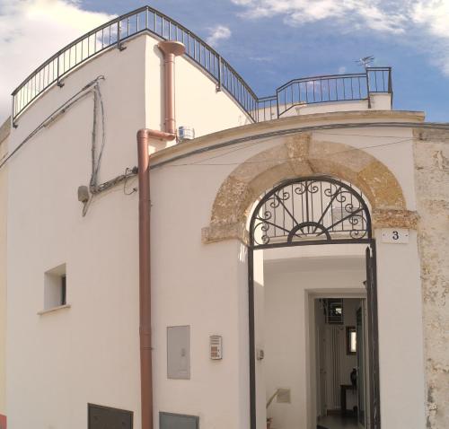 an entrance to a white building with an archway at Casa Margherita - typical salento house in Castrignano del Capo