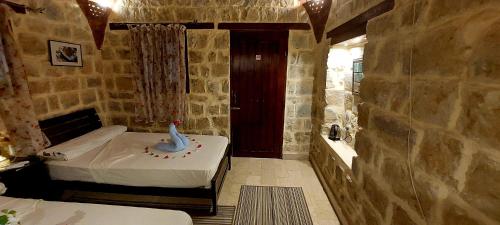a bedroom with a bed in a stone wall at palm shadow resort in Tunis
