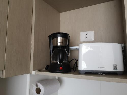 una macchinetta del caffè su una mensola accanto a una stampante di Tranquilo y Acogedor departamento en Con Con a Concón