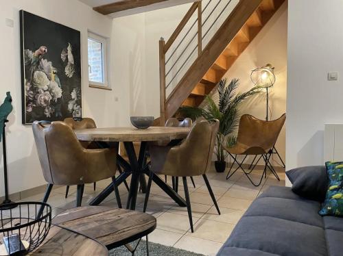 un salon avec une table et des chaises en bois dans l'établissement D1ouD3 CHIC, CHARME, QUALITÉ -de 10 min de la plage, à Ingouville