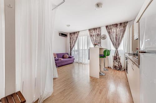 ARI Purple Studio في أراد: غرفة معيشة مع أريكة أرجوانية ومطبخ