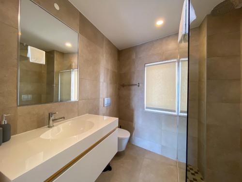 un bagno con lavandino, WC e specchio di Estúdio com Fantástica Vista Mar - Praia da Luz a Luz