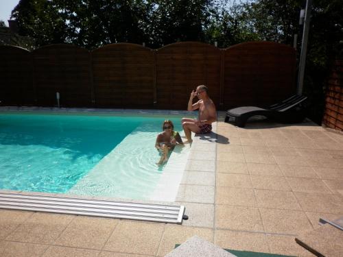 a woman and a child playing in a swimming pool at Luxury Villa Heviz in Hévíz
