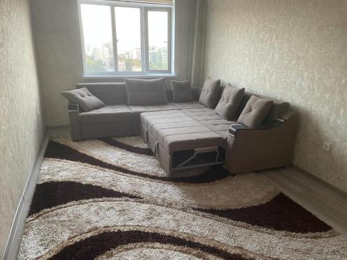 un soggiorno con divano e finestra di Appartement Kholova a Dushanbe