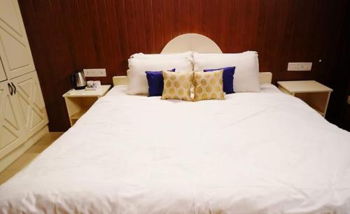 a large white bed with two pillows on it at Fort Bridge View in Cochin