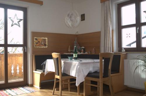 ein Esszimmer mit einem Tisch und einigen Fenstern in der Unterkunft Apartment Turala in Prutz