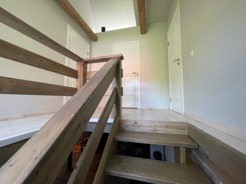 a stairwell in a house with a wooden railing at Apartamenti MEKE in Limbaži