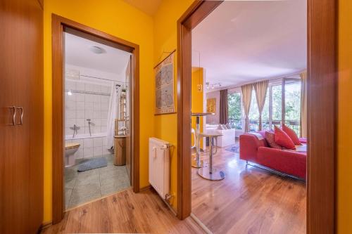 ein Wohnzimmer mit gelben Wänden und einer roten Couch in der Unterkunft Inspirarta Studio in Budapest