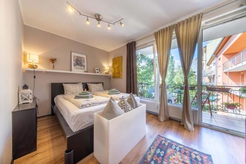 ein Schlafzimmer mit einem Bett und einem großen Fenster in der Unterkunft Inspirarta Studio in Budapest