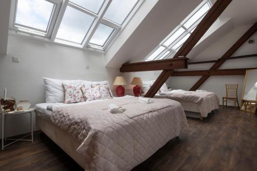 a bedroom with two beds and two windows at Golden Tree Loft in the Heart of Prague in Prague