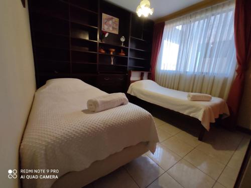 a hotel room with two beds and a window at Departamentos Vacacionales en el centro de Tarija in Tarija