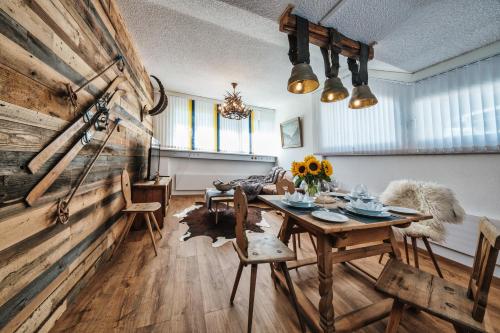 a dining room with a table and a wooden wall at Casa Capricorn in Davos