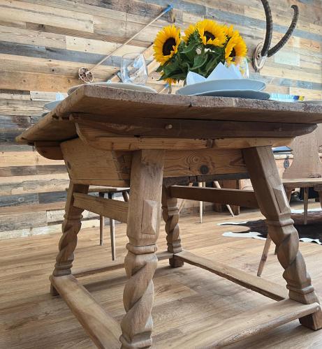 a wooden table with a vase of sunflowers on it at Casa Capricorn in Davos