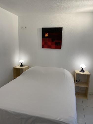 a bedroom with a white bed with two night stands at StudioC hyper-centre climatisé in Albi