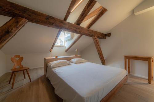 1 dormitorio con 1 cama blanca en el ático en BELABRI'- centralissime mansarde charme&comfort CIR 0215-0216 en Aosta