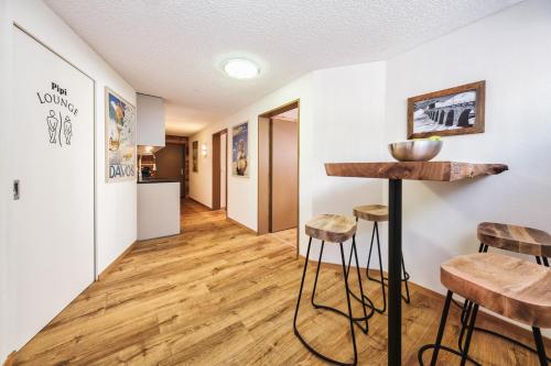 a hallway with a table and stools in a room at Casa Capricorn in Davos