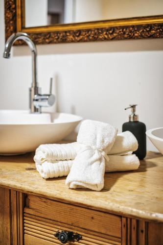 a pile of towels on a bathroom counter with a sink at Casa Capricorn in Davos