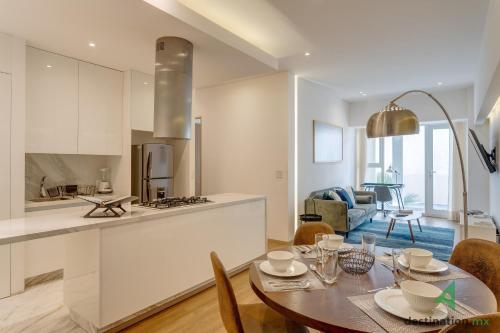 a kitchen and living room with a dining table and a kitchen at Lovely & Spacious Apartment with Pool & Gym in La Condesa - Icon in Mexico City