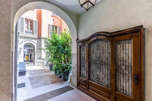 - une entrée pour une maison avec une porte en bois dans l'établissement VIA DELLA SPIGA N50 - Luxury Loft in the Heart of the Fashion District, à Milan