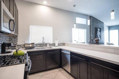 a kitchen with a sink and a stove top oven at Modern Home! Pool & Jacuzzi (30% off for longterm) in Las Vegas
