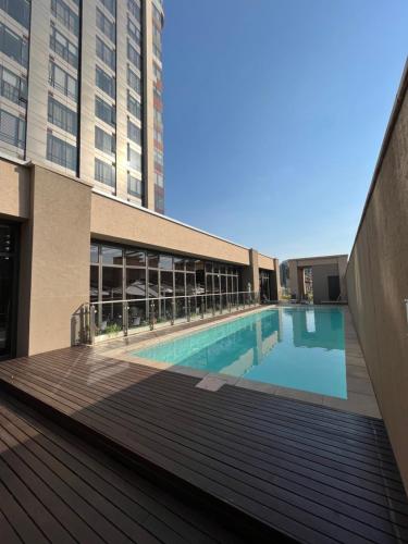 a swimming pool on the side of a building at A cozy apartment at Sandton Skye in Johannesburg