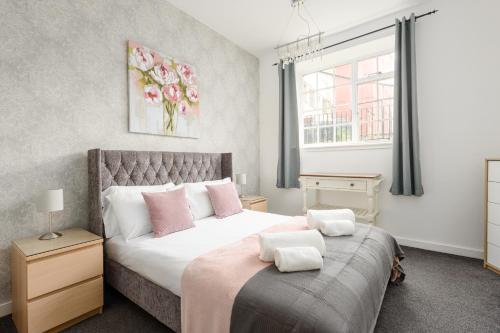 1 dormitorio con 1 cama grande con almohadas rosas en 2 BR Royal Mile Apartment en Edimburgo