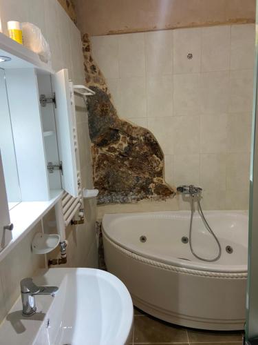 a bathroom with a bath tub and a sink at Ifigenia Theriso Village in Thérison