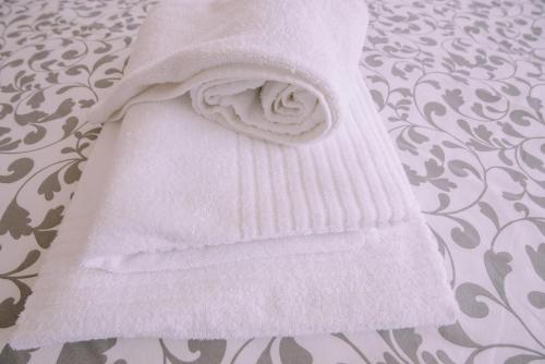 Una toalla blanca está en una cama en Casa Dona Ermelinda - Silêncio - Conforto - Natureza en Outeiro Maior