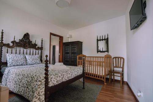 a bedroom with a bed and a mirror and a chair at Casa Dona Ermelinda - Silêncio - Conforto - Natureza in Outeiro Maior