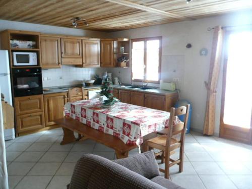 - une cuisine avec une table et un arbre de Noël dans l'établissement Appartement en Triplex 5 pièces 8 personnes avec Terrasse, Balcon et Parking - Exposé Sud - FR-1-263-307, à Valloire