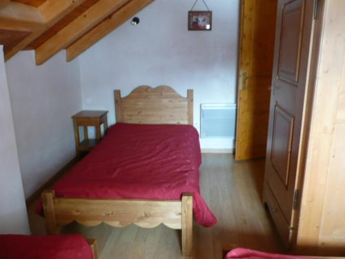 - une chambre avec un lit en bois et une couverture rouge dans l'établissement Appartement en Triplex 5 pièces 8 personnes avec Terrasse, Balcon et Parking - Exposé Sud - FR-1-263-307, à Valloire