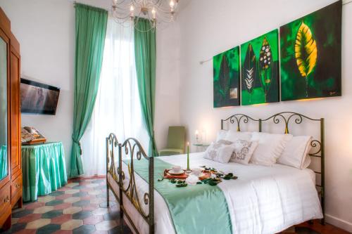 a bedroom with a bed with a green and white comforter at Romance al Colosseo in Rome