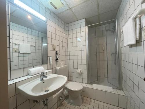 a bathroom with a sink and a toilet and a shower at Hotel Meilchen in Dillingen an der Saar