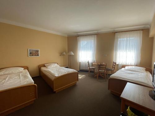 um quarto de hotel com duas camas e uma mesa em Hotel Meilchen em Dillingen