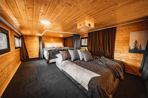 1 dormitorio con 3 camas en una habitación con paredes de madera en Secret Lake Prag magic place relaxation& wellness, en Řehenice