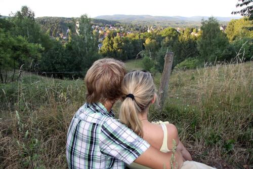 a man and woman sitting on top of a hill at Ferienwohnung-Stricker-Bad-Sachsa in Bad Sachsa