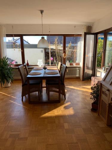 a dining room with a table and some chairs at Helle Wohnung mit Wintergarten, Terrasse und Garten in Bad Liebenzell