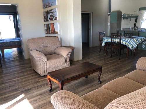 a living room with a couch and chairs and a table at Daberas Guest Farm in Augrabies