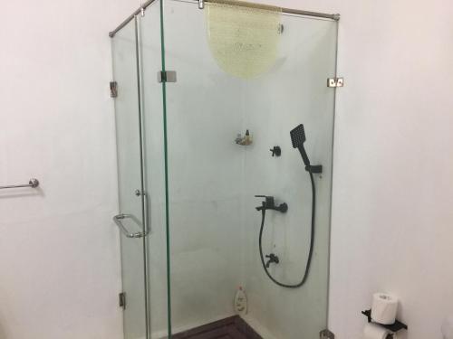 W łazience znajduje się prysznic ze szklanymi drzwiami. w obiekcie Paradise holidays in the tropics w mieście Kottanitivu