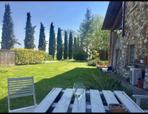 a picnic table with a glass of wine on a yard at Cà Vittoria in Desenzano del Garda