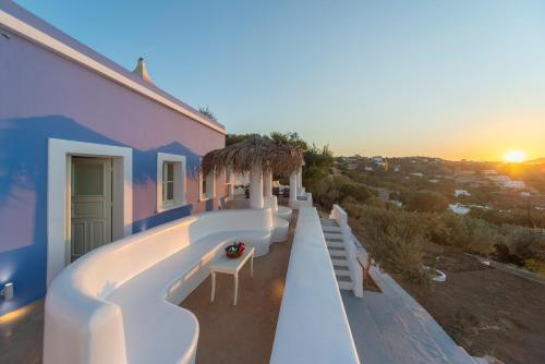 a house with a balcony with a sunset in the background at Hidden Oasis Private Villa in Agia Marina