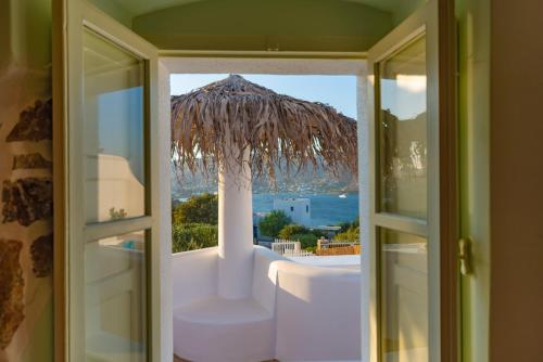 a bathroom with a view of the ocean and a straw umbrella at Hidden Oasis Private Villa in Agia Marina