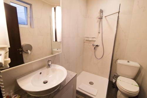 a bathroom with a sink and a toilet and a shower at Hotel Belvedere in Braşov