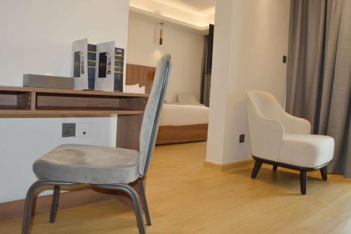 a room with two chairs and a desk and a bed at AXIL HÔTEL in Dakar