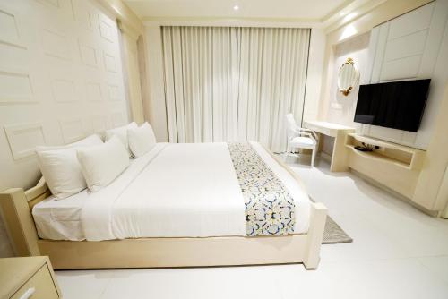 a hotel room with a bed and a television at AJ Grand Hotel in Mangalore