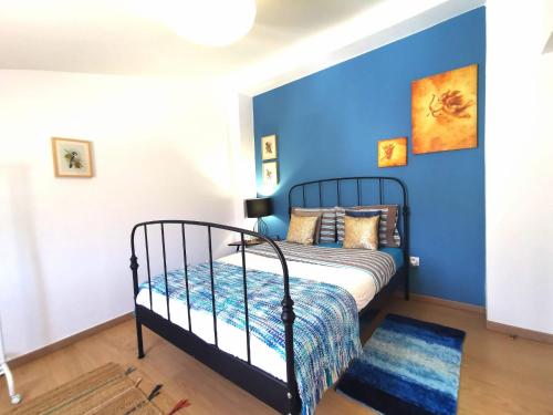 1 dormitorio con 1 cama con pared azul en Silves Country Room, en Silves