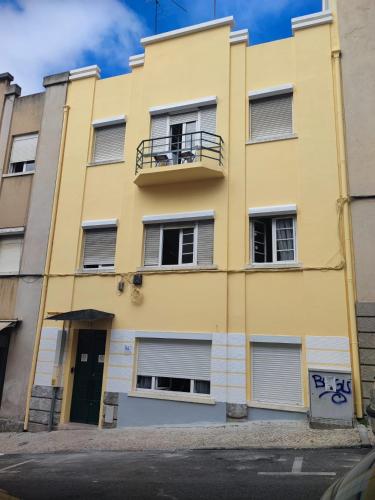 a yellow building with a balcony at PARAISO Da PENHA in Lisbon
