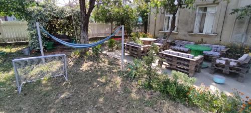 a backyard with a hammock and chairs and a fence at Guest House Tall Rooms in Zugdidi